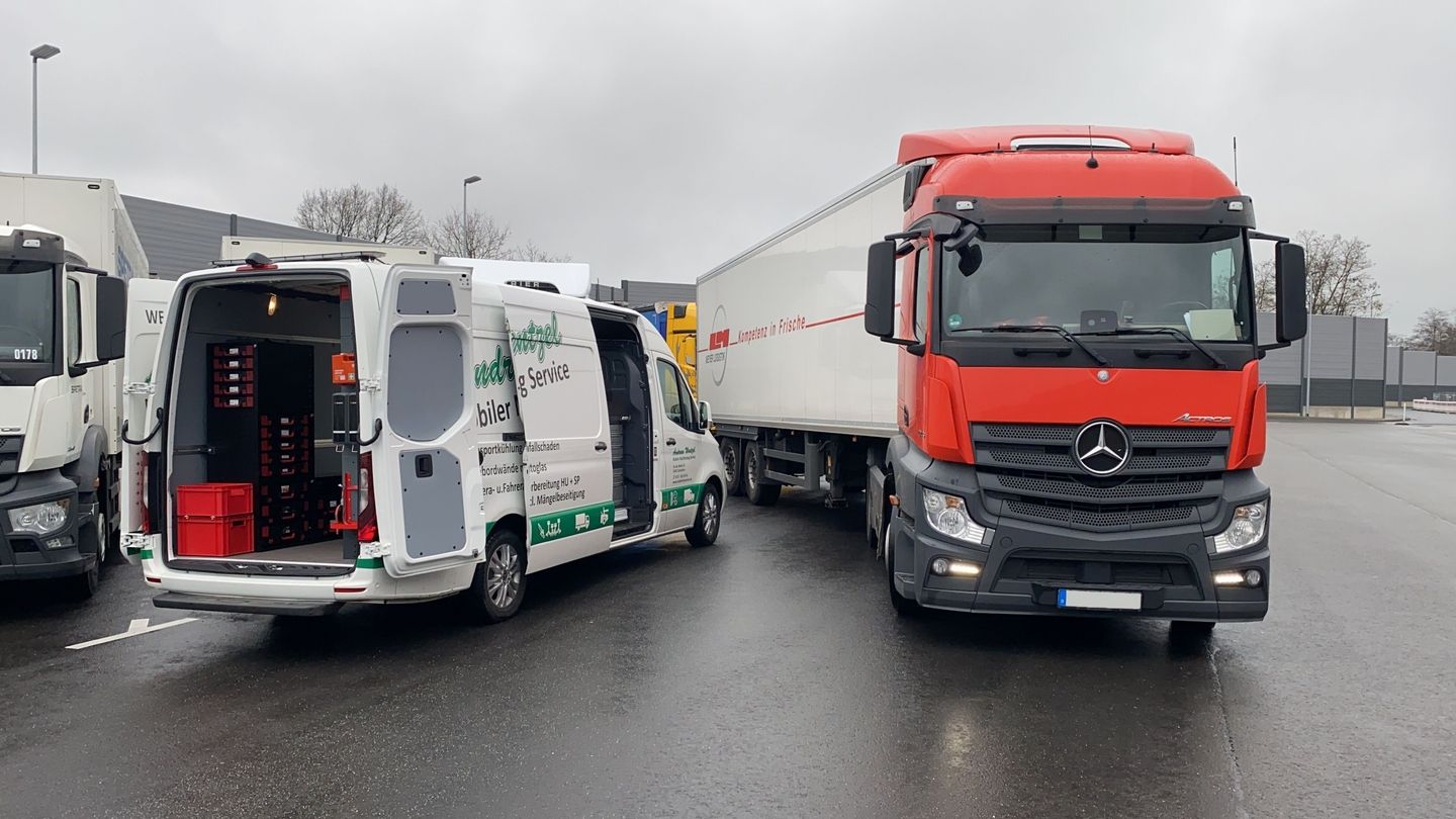 Zwei Lkw stehen nebeneinander geparkt auf einer Straße